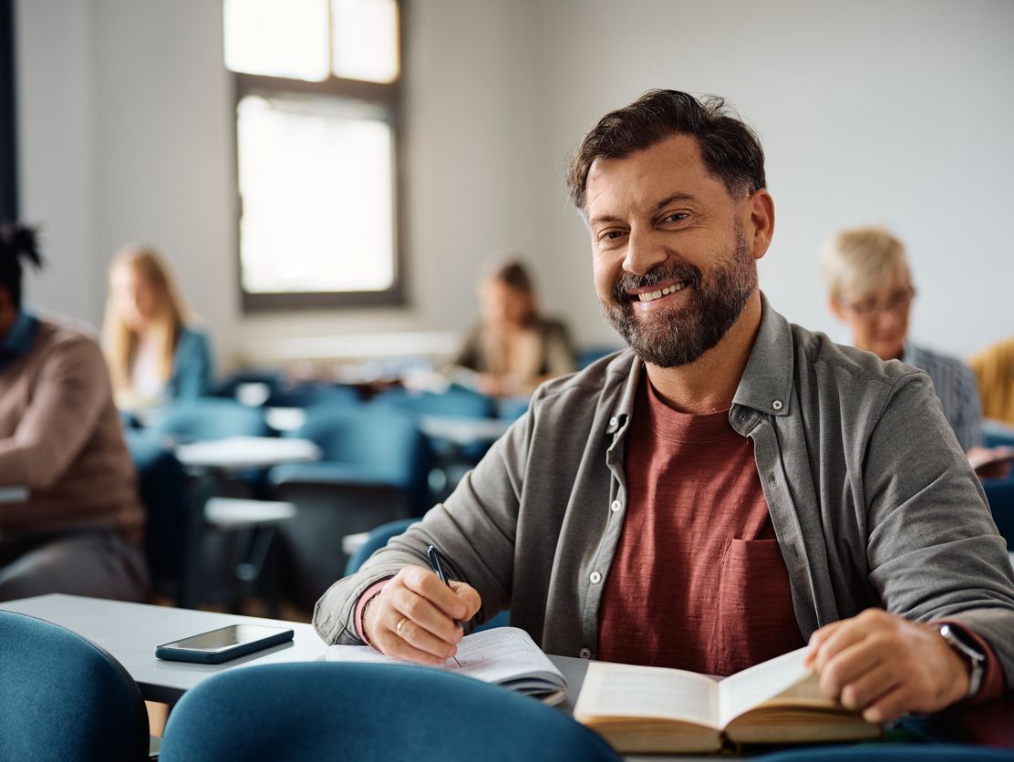 Smilende middeladrende mann i et klasserom