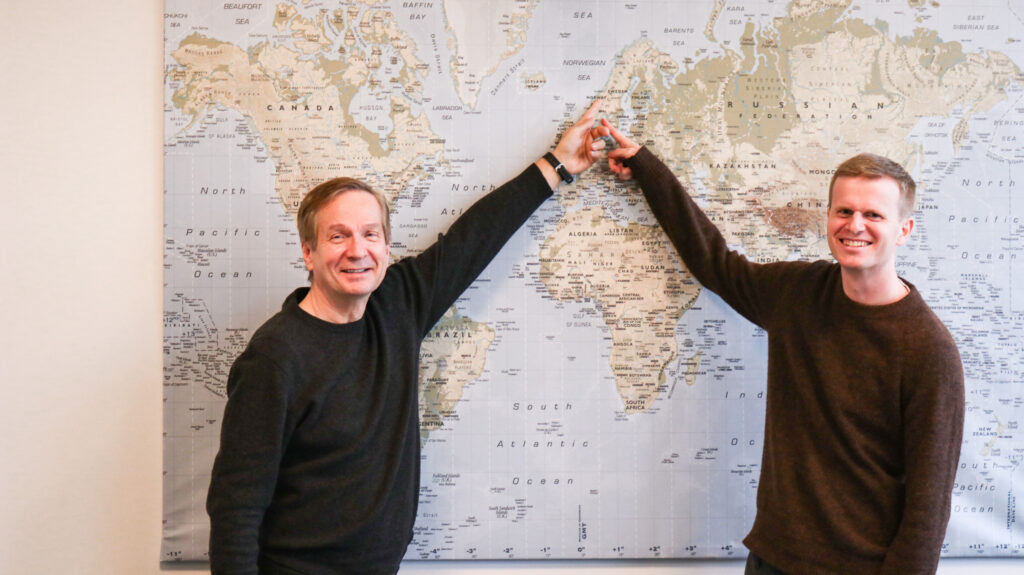 Photo of Karl Johansen and Preben Hegland pointing on a map 