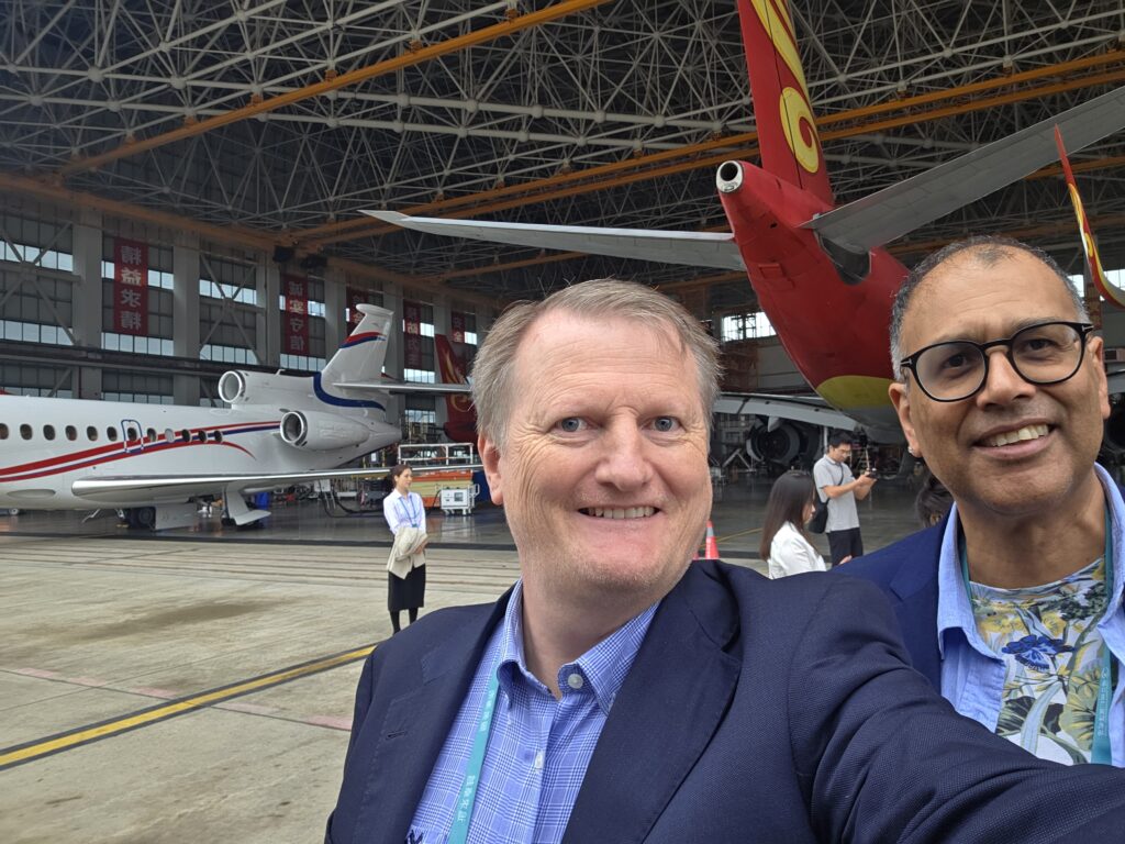 Bilde av Nils-Erik og Roger. I bakgrunnen er to fly og flere mennesker.